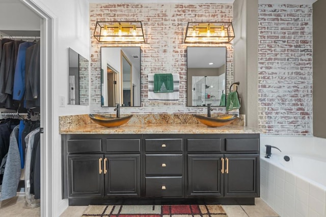 bathroom featuring tiled bath, vanity, and tile patterned flooring