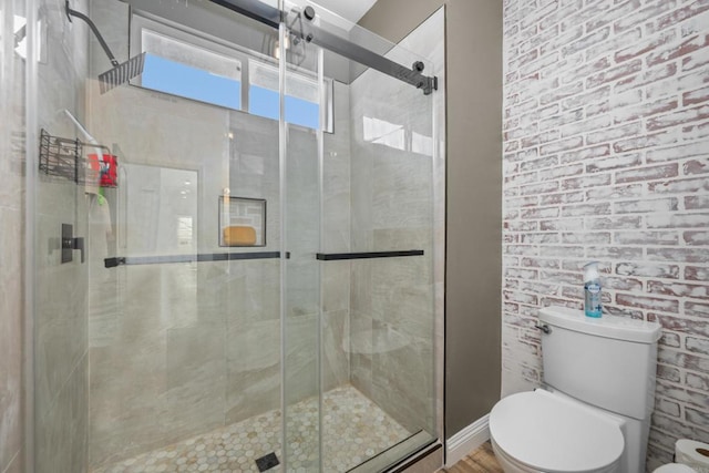 bathroom featuring toilet and a shower with shower door