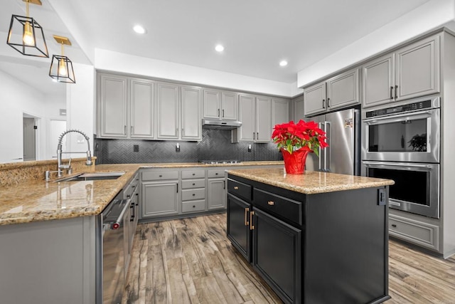 kitchen with kitchen peninsula, gray cabinets, stainless steel appliances, decorative light fixtures, and sink