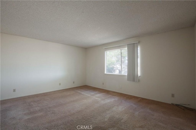 carpeted empty room featuring a textured ceiling