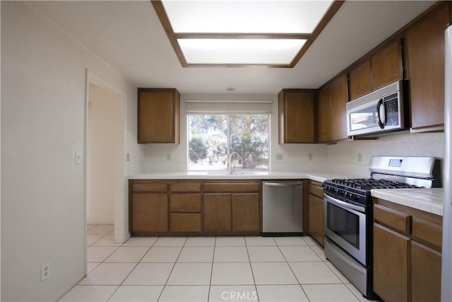 kitchen with sink, light tile patterned floors, dishwasher, and gas stove