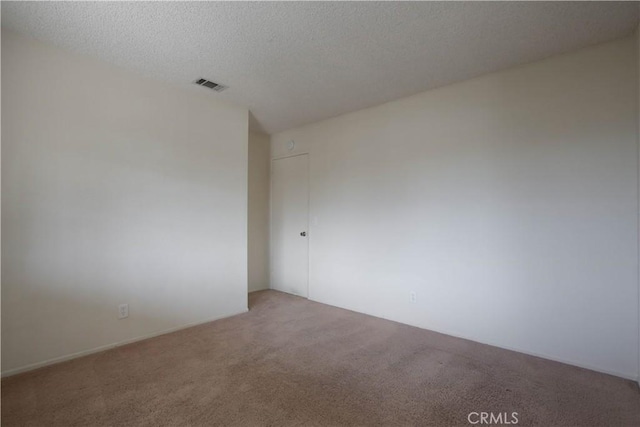 empty room with a textured ceiling and carpet flooring