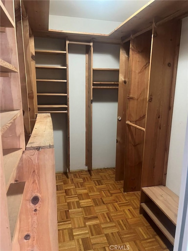 walk in closet with light parquet floors