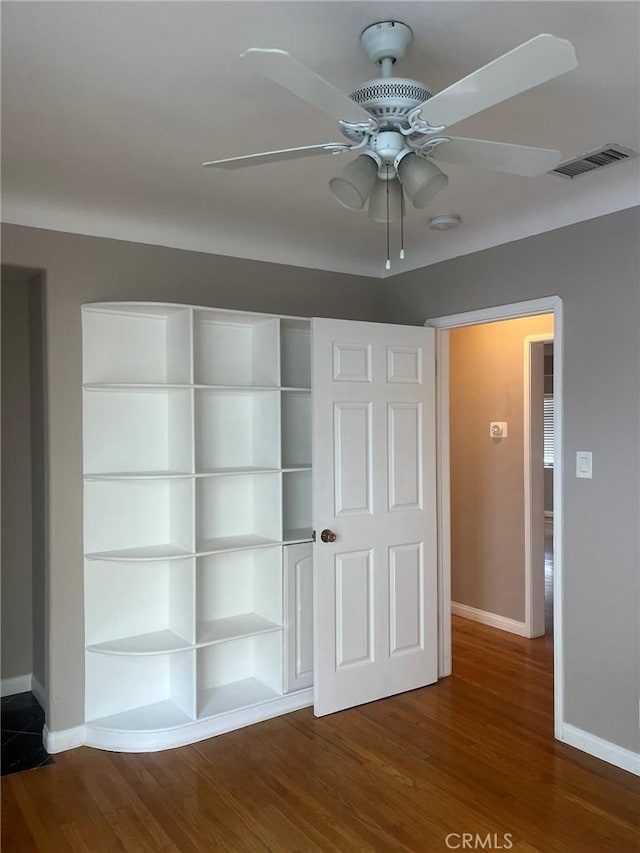 unfurnished bedroom featuring ceiling fan, a closet, and wood-type flooring