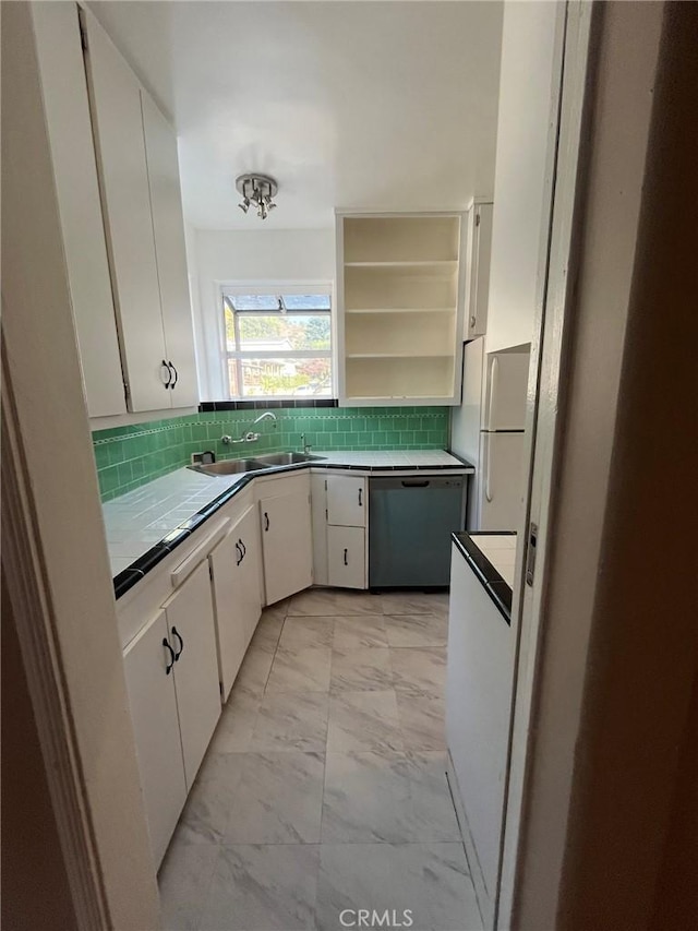 kitchen with white cabinetry, sink, white refrigerator, and dishwashing machine