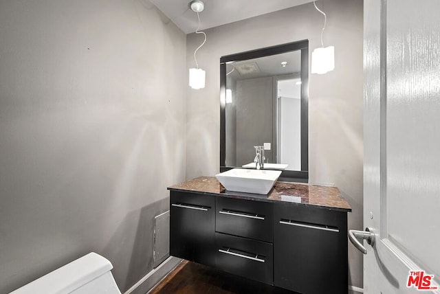 bathroom with toilet, hardwood / wood-style flooring, and vanity