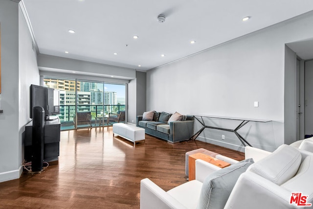 living room with dark wood-type flooring and ornamental molding