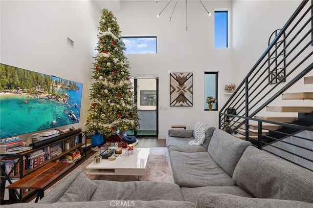 living room featuring hardwood / wood-style flooring, a towering ceiling, and plenty of natural light