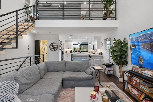 living room with hardwood / wood-style floors and a towering ceiling