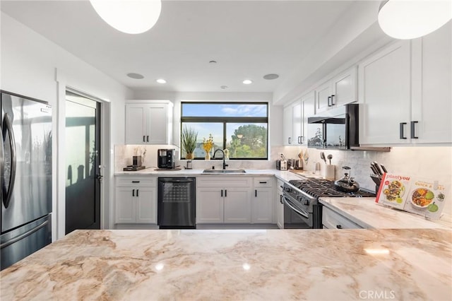 kitchen featuring white cabinets, appliances with stainless steel finishes, sink, and light stone counters