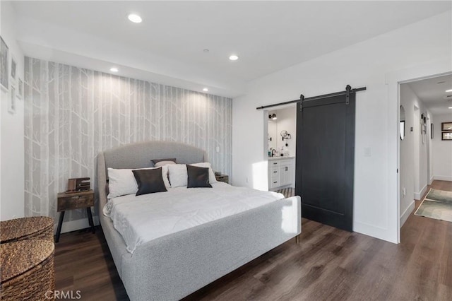 bedroom with dark hardwood / wood-style flooring and a barn door