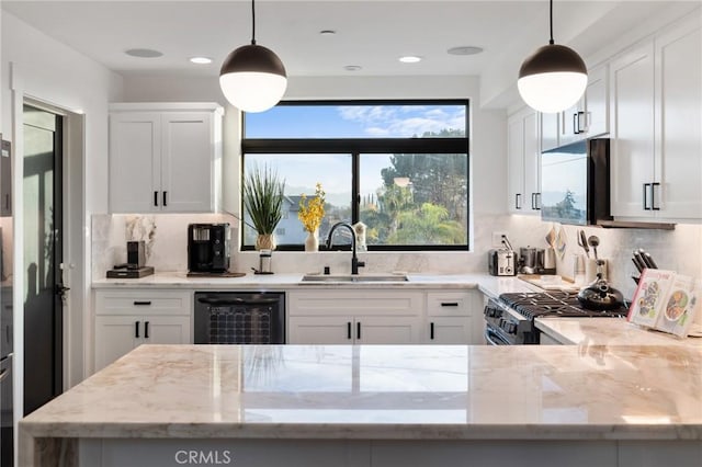 kitchen with white cabinetry, sink, and hanging light fixtures