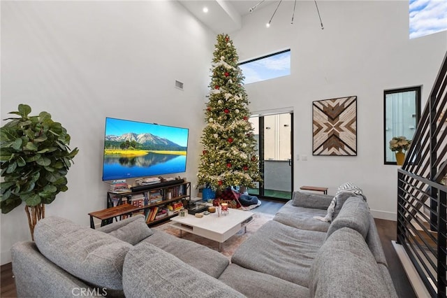 living room with hardwood / wood-style floors and a towering ceiling