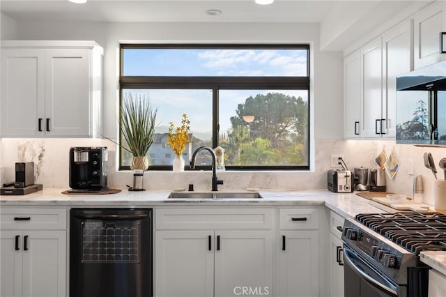 kitchen featuring appliances with stainless steel finishes, white cabinetry, sink, light stone counters, and range hood