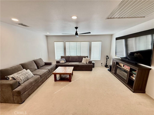 carpeted living room with ceiling fan