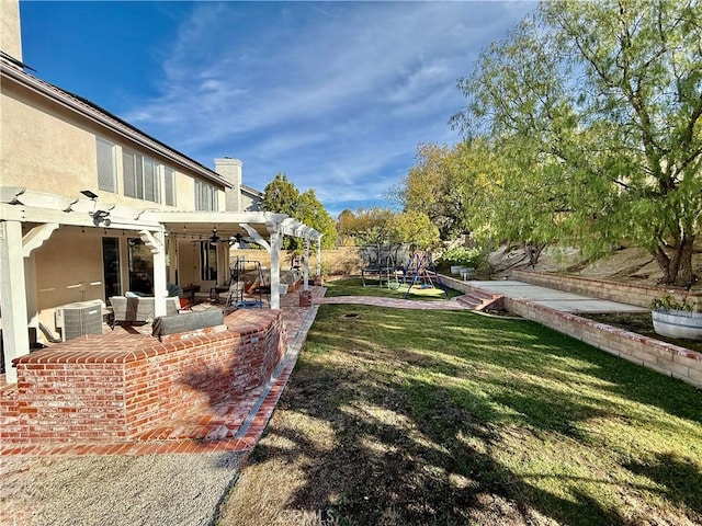 view of yard with a trampoline, a pergola, and a patio area