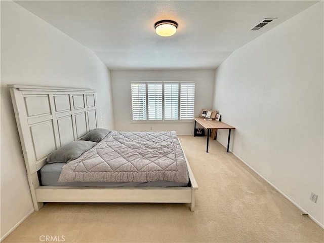 bedroom with light colored carpet and vaulted ceiling