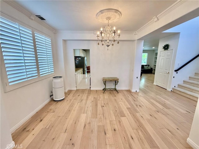 dining space featuring an inviting chandelier, ornamental molding, and light hardwood / wood-style flooring