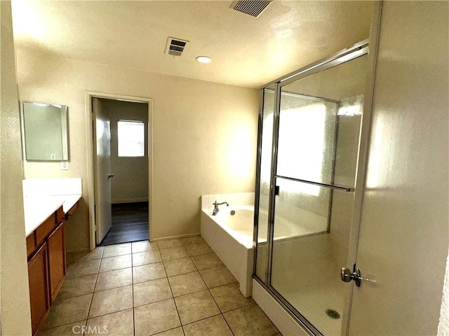 bathroom featuring tile patterned flooring, vanity, and plus walk in shower