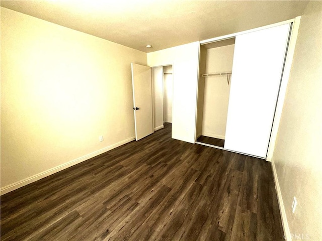 unfurnished bedroom featuring dark wood-type flooring and a closet