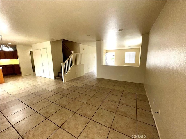 spare room featuring a textured ceiling and tile patterned floors