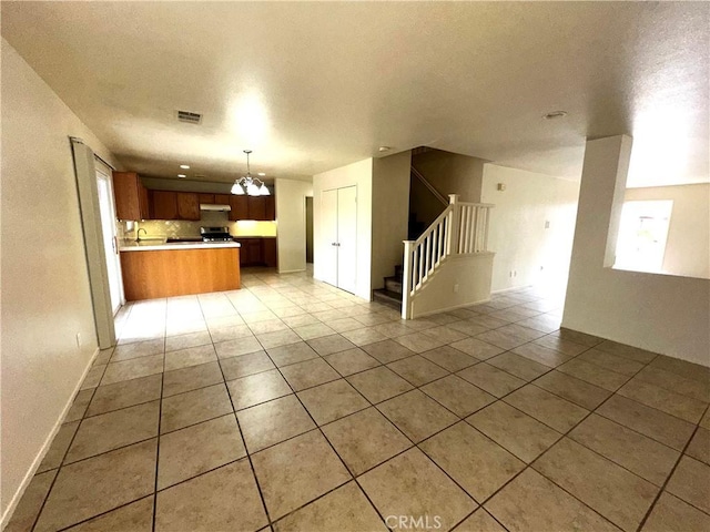 kitchen with a chandelier, hanging light fixtures, light tile patterned floors, and decorative backsplash