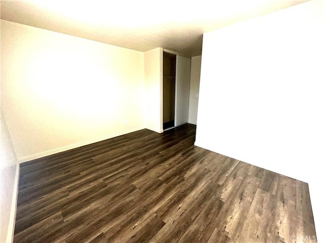 unfurnished room with dark wood-type flooring