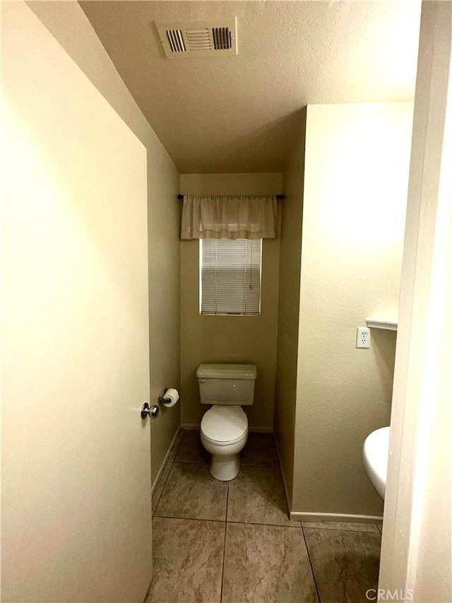 bathroom with toilet and tile patterned flooring