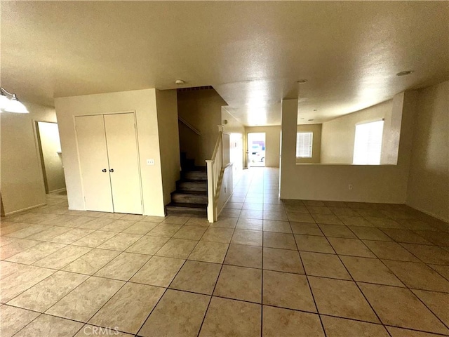 empty room featuring light tile patterned flooring and a textured ceiling