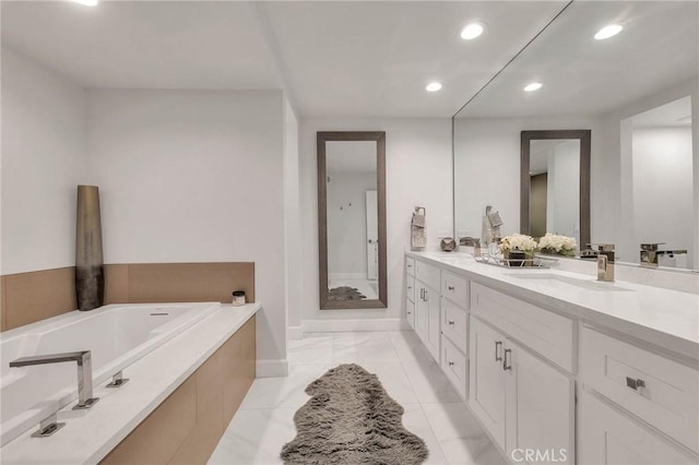 bathroom featuring tiled bath and vanity