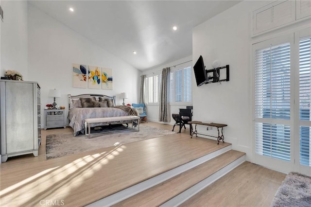 bedroom featuring light wood-type flooring and high vaulted ceiling