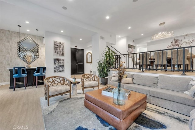 living room with light wood-type flooring and an inviting chandelier