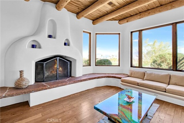 unfurnished living room featuring wooden ceiling, hardwood / wood-style floors, and beamed ceiling