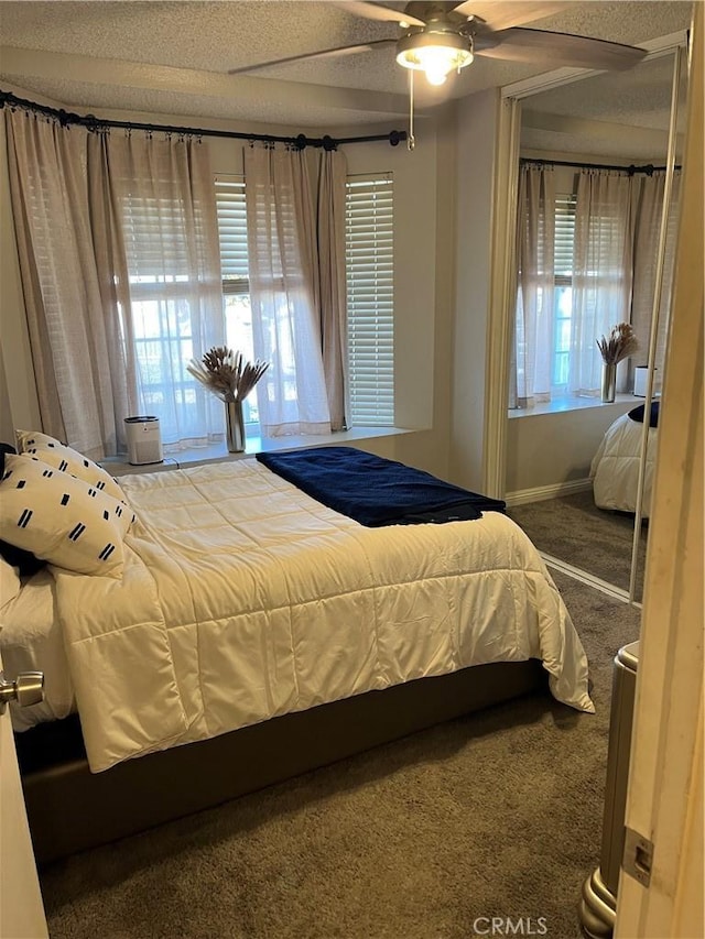 bedroom with a textured ceiling, ceiling fan, and carpet