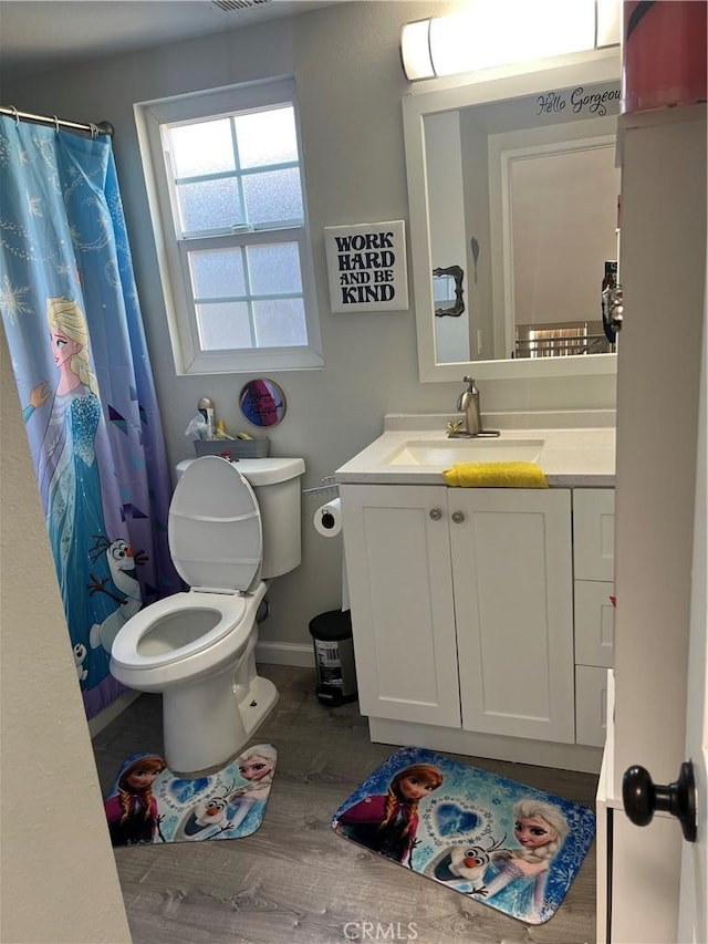 bathroom with toilet, a shower with shower curtain, hardwood / wood-style flooring, and vanity