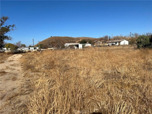 view of yard with a rural view and a mountain view