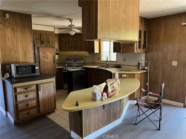 kitchen featuring ceiling fan, a kitchen island, a kitchen bar, sink, and stainless steel appliances