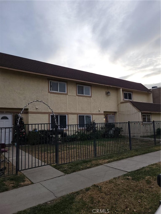 view of property featuring a fenced front yard and stucco siding