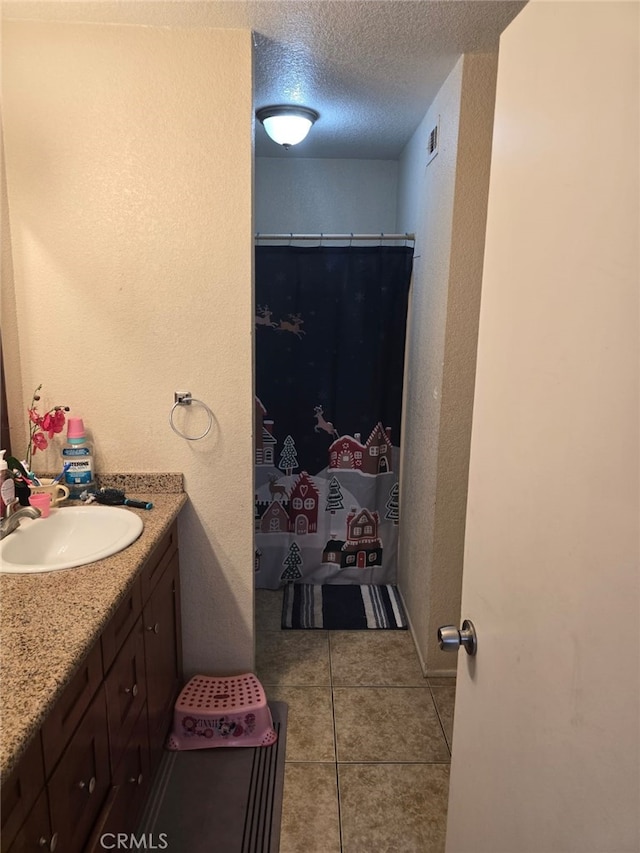 bathroom featuring curtained shower, visible vents, a textured ceiling, vanity, and tile patterned floors