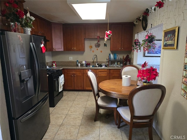 kitchen featuring black appliances, light countertops, a sink, and light tile patterned flooring