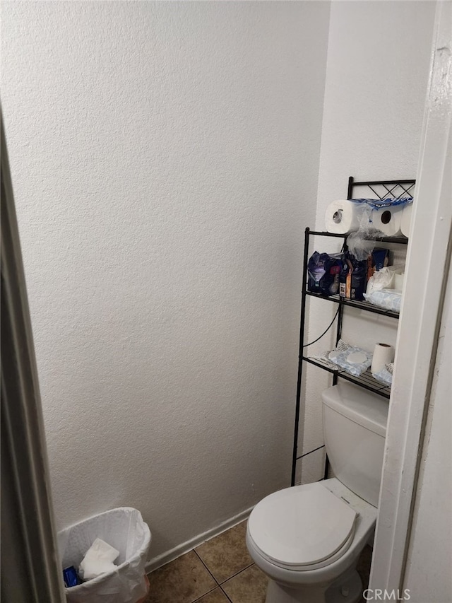 bathroom featuring tile patterned flooring, toilet, and baseboards