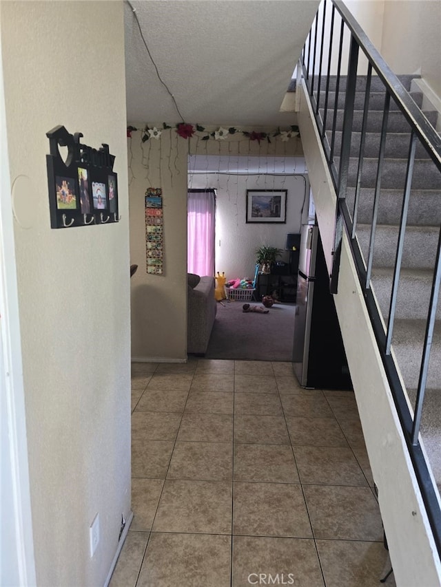 corridor with stairway and tile patterned floors