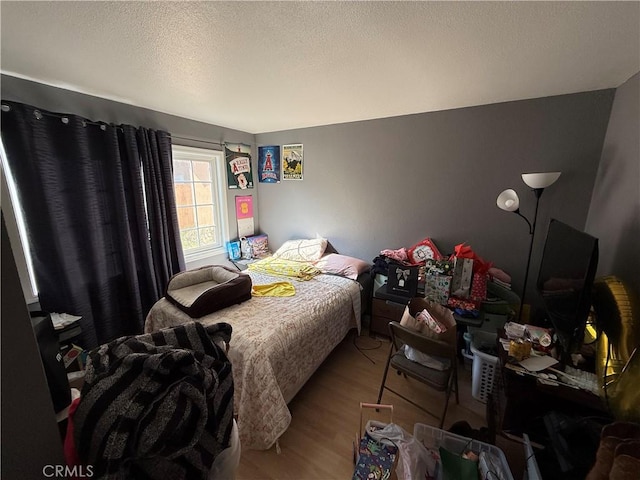 bedroom featuring a textured ceiling and light hardwood / wood-style flooring