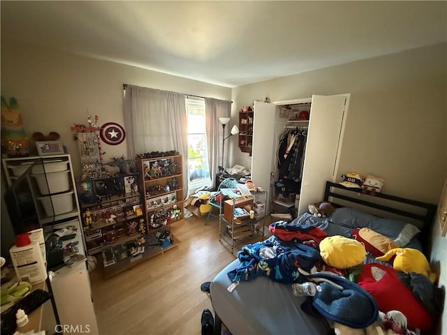 bedroom with light wood-type flooring and a closet