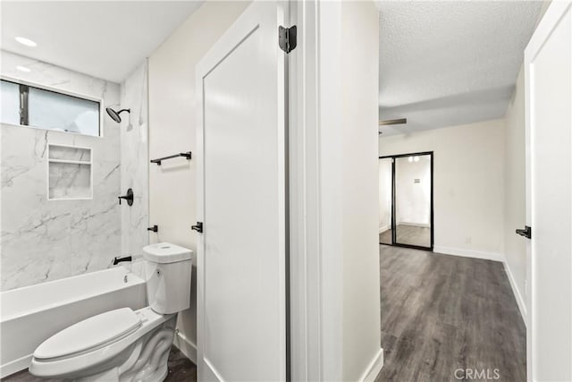 bathroom featuring toilet, tiled shower / bath combo, a textured ceiling, and hardwood / wood-style floors