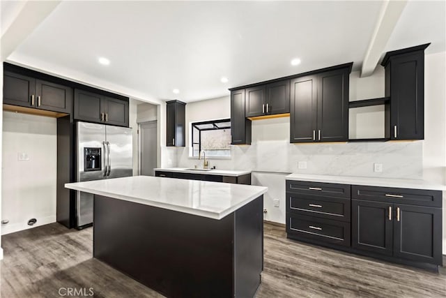 kitchen with sink, hardwood / wood-style floors, stainless steel fridge, and a center island