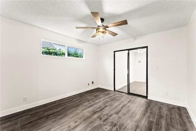 unfurnished bedroom with a textured ceiling, ceiling fan, and dark hardwood / wood-style floors