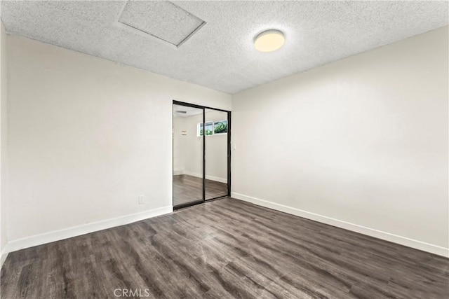 unfurnished bedroom with a closet, dark hardwood / wood-style flooring, and a textured ceiling