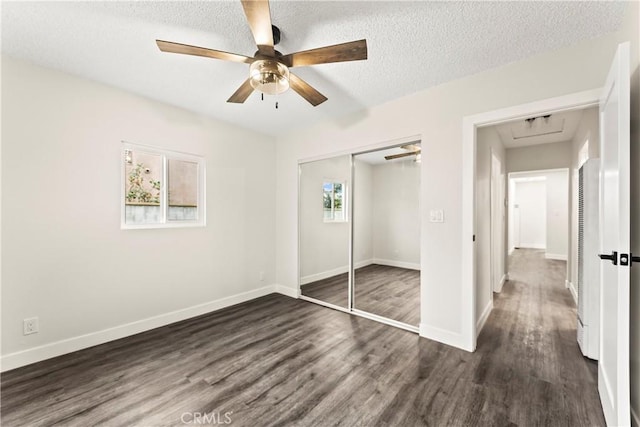 unfurnished bedroom with ceiling fan, dark wood-type flooring, a textured ceiling, and a closet