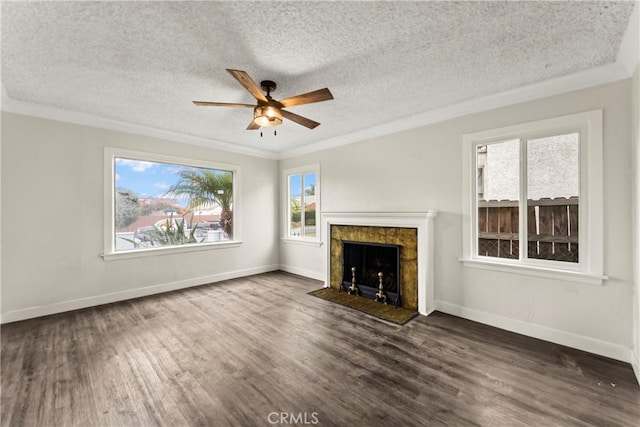 unfurnished living room featuring ceiling fan, plenty of natural light, dark hardwood / wood-style flooring, and a fireplace